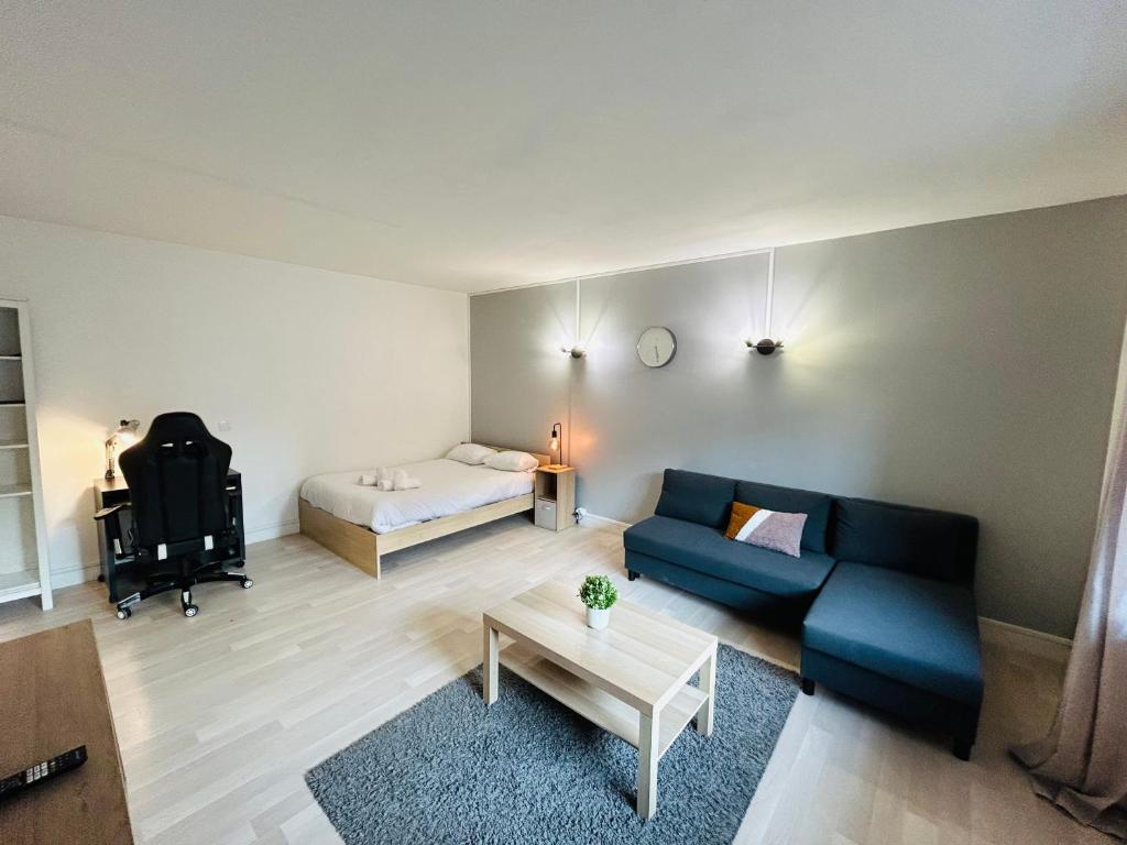 een woonkamer met een bank en een bed bij La Suite Victor Hugo - Centre-ville - Taittinger in Reims
