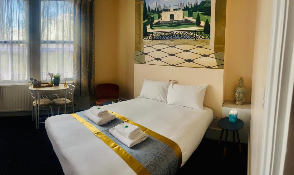 Una habitación de hotel con una cama con toallas. en United Lodge Hotel, en Londres
