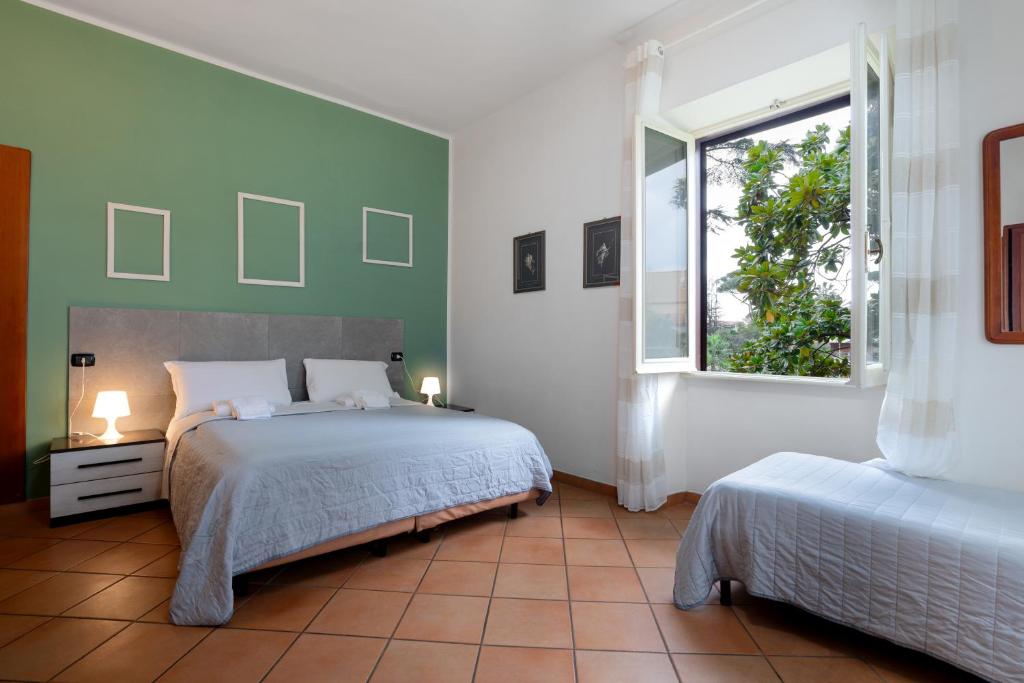 1 dormitorio con 2 camas y ventana en Comfort Rooms Villa Gaia Tor Vergata, en Roma