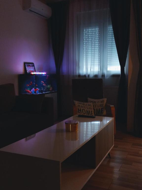 a living room with a table and a tv at TOP Apartman in Šabac