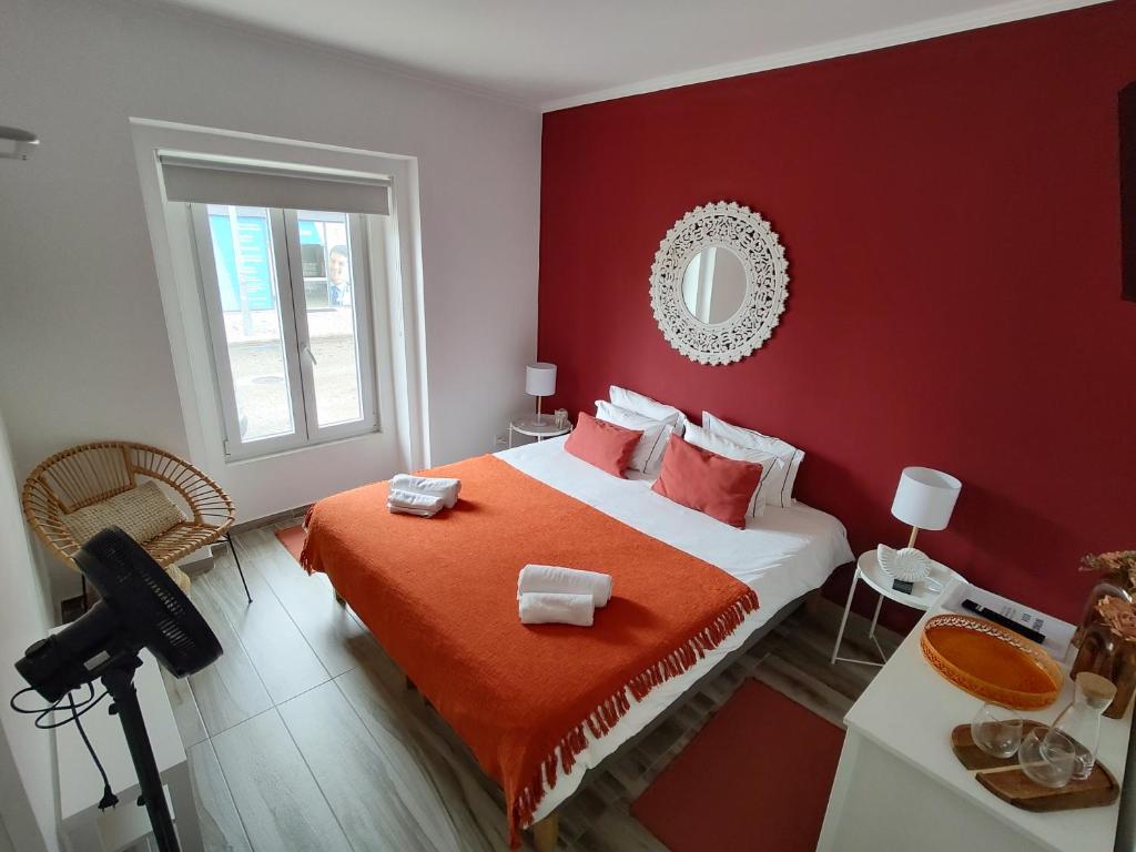 czerwona sypialnia z łóżkiem z czerwoną ścianą w obiekcie Costa Paradise Beach w Costa de Caparica
