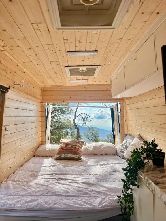 1 cama en una casa pequeña con ventana en Van Camper Ibiza MB100 Van Voyage, en Sant Carles de Peralta