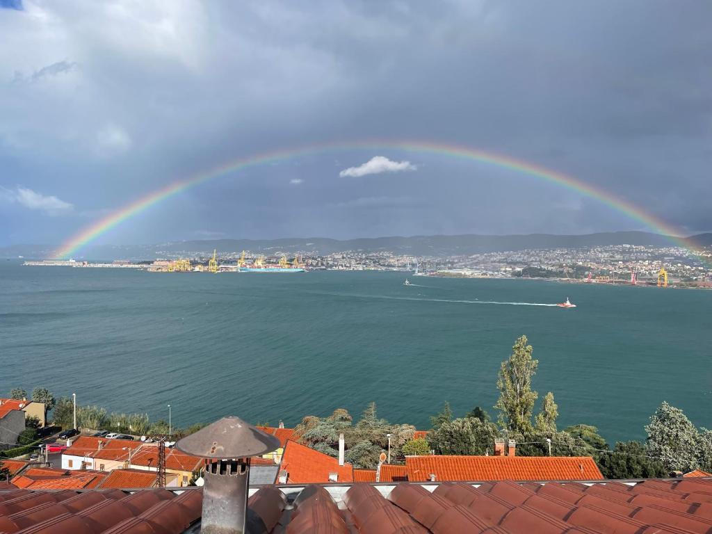 a rainbow in the sky over the water at Panorama Hotel in Muggia