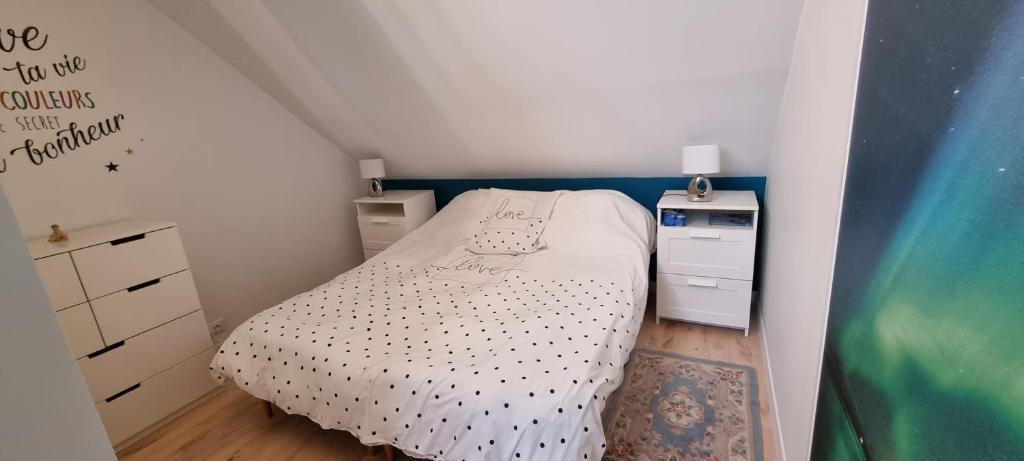 een kleine slaapkamer met een bed en een dressoir bij LA CLOSERIE in Maurepas