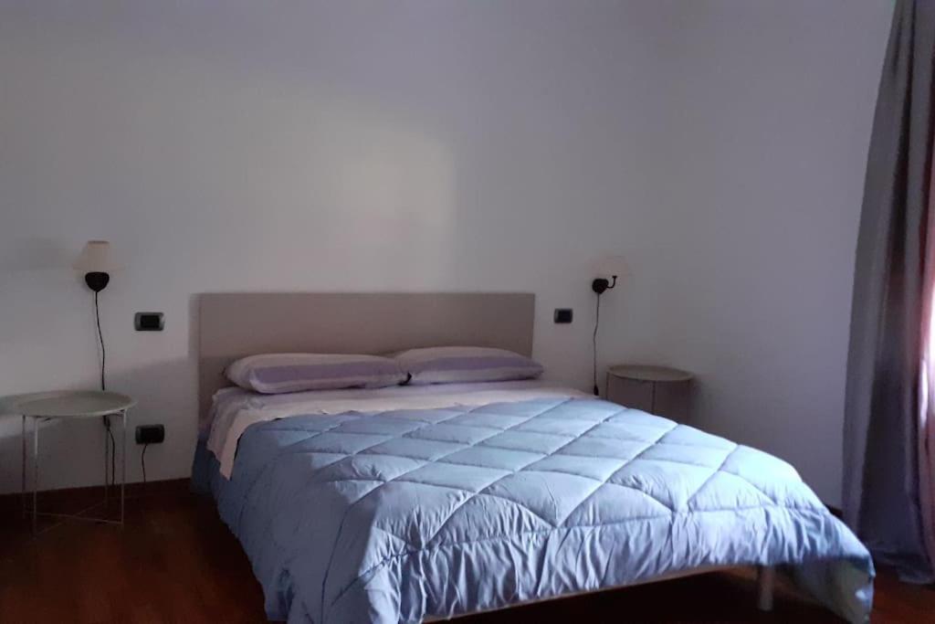 ein Bett mit blauer Decke in einem Schlafzimmer in der Unterkunft lo Tsanty casa vacanza in Aosta