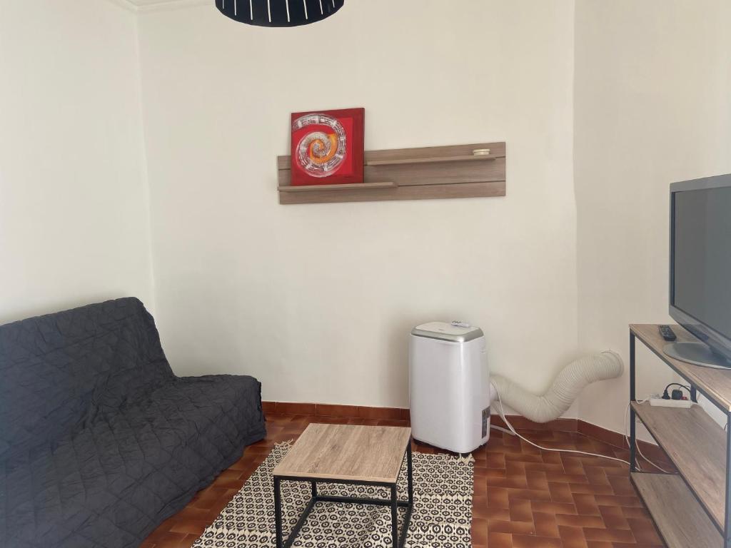 un salon avec un canapé et une télévision dans l'établissement T2 Marché de Bastia, à Bastia