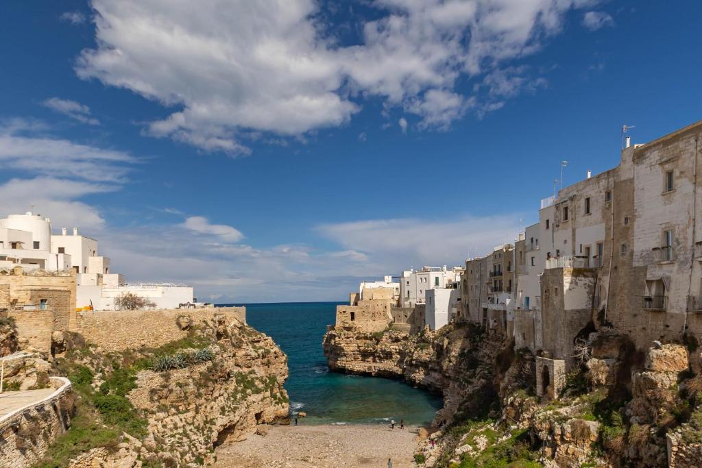 a group of buildings on a cliff next to the ocean at Casetta : Polignano in Polignano a Mare