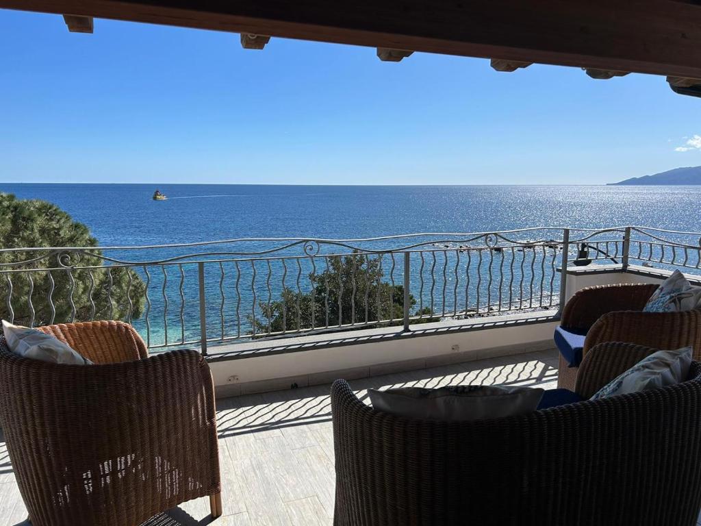 a balcony with chairs and a view of the ocean at DOLCE VITA holiday home in Cala Gonone