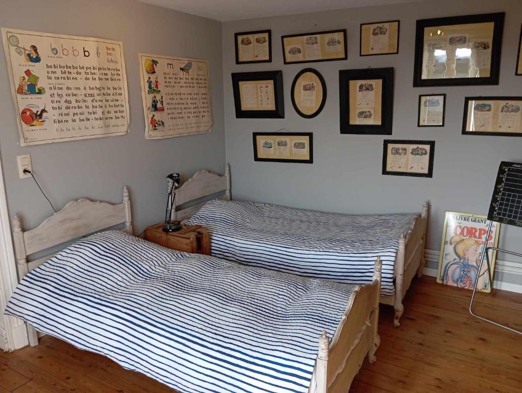 Duas camas num quarto com fotografias na parede em La chapelle em Dinant
