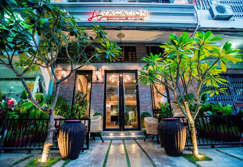 a restaurant with trees in front of a building at Vacation Boutique Hotel in Phnom Penh