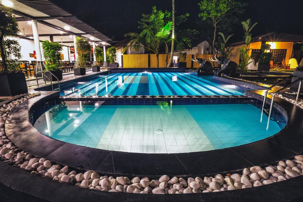 a swimming pool in a hotel at night at Hotel Flower Garden in Unawatuna
