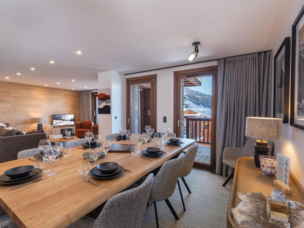 une salle à manger avec une grande table et des chaises en bois dans l'établissement Appartement raffiné à Courchevel Moriond pour 8 personnes, proche pistes et commerces - FR-1-563-148, à Courchevel