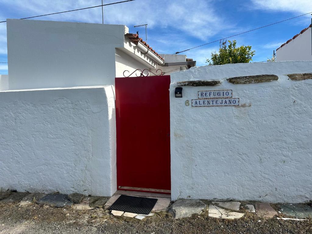 ein rot-weißes Gebäude mit einer roten Tür in der Unterkunft Refúgio Alentejano in Estremoz