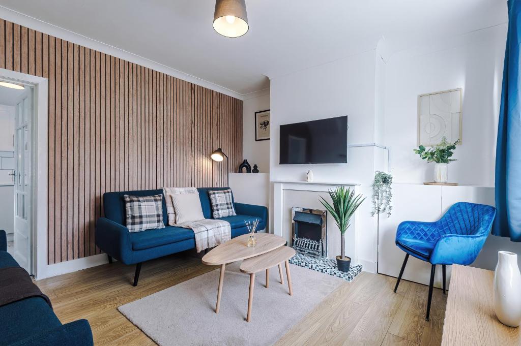 - un salon avec un canapé bleu et une cheminée dans l'établissement Stylish House in Stalybridge with WiFi & Parking Sleeps 8 by PureStay, à Stalybridge