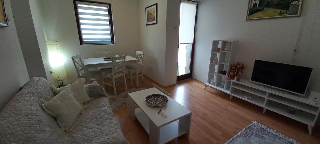 a living room with a couch and a tv and a table at Apartman Milic in Soko Banja