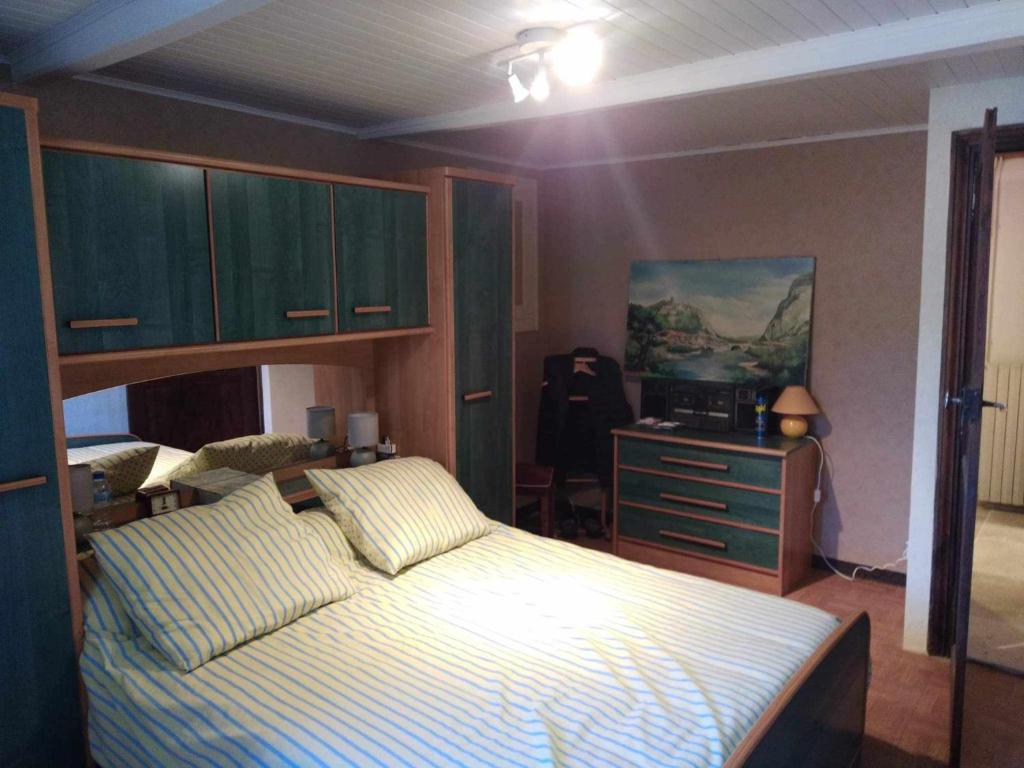 een slaapkamer met een bed en een dressoir bij La forestière 