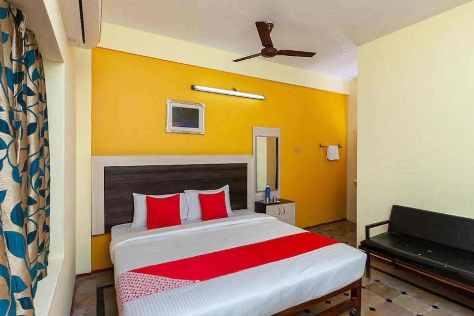 a bedroom with a large bed with red pillows at HOTEL SIVA SAKTHI in Tiruvannāmalai