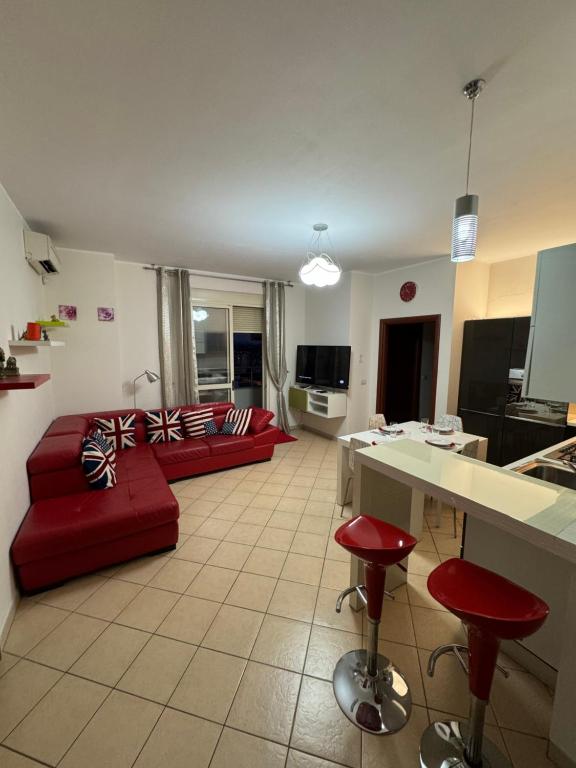 een woonkamer met een rode bank en rode krukken bij 3 Bedrooms Apartment in Shkodër