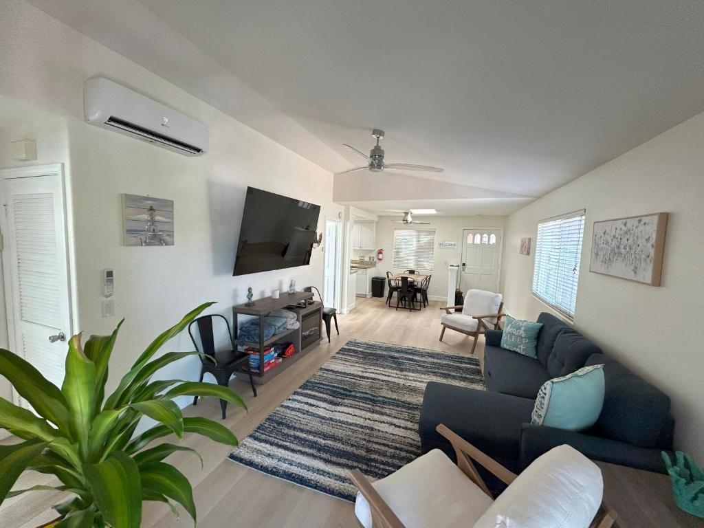 a living room with a blue couch and a tv at Oceanside Getaway at Tuscan Village Condominiums in Oceanside