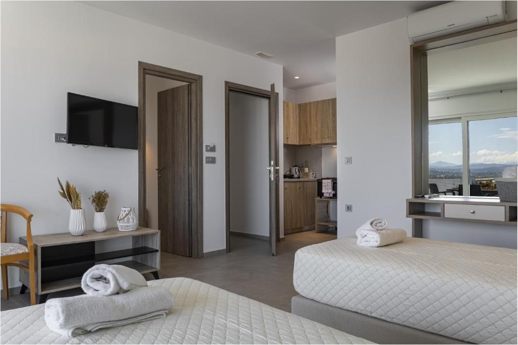 1 dormitorio blanco con 2 camas y lavamanos en ARETI LUXURY APARTMENTS en Georgioupolis