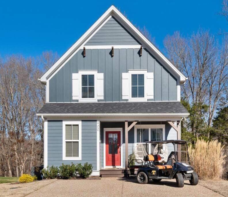 una casa con un carro de golf estacionado frente a ella en Lakeside Cottage w/Golf Cart, Hot Tub, & Fire Pit, en Estill Springs
