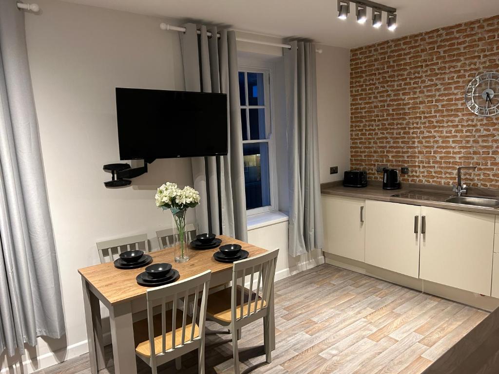 cocina con mesa y TV en la pared en Modern 2 bedroom apartment - Neath Town centre, en Neath