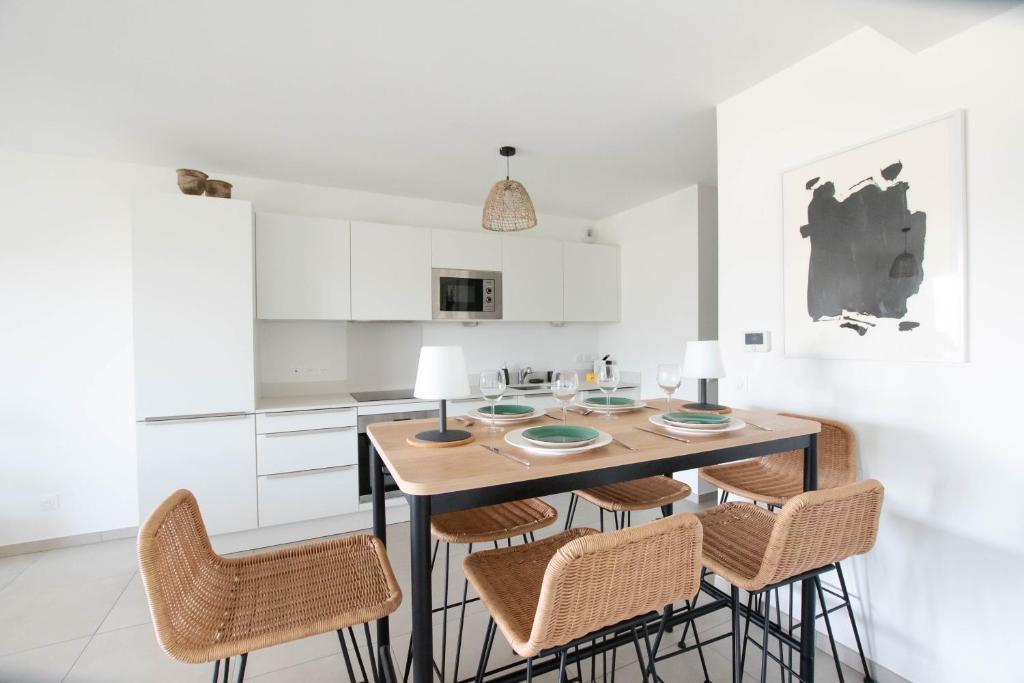 une cuisine avec une table et des chaises en bois dans l'établissement Le Bonamour - Élégance et sérénité entre plage et port, à Capbreton