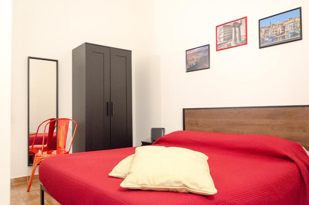 ターラントにあるDowntown Lodge Museumの赤いベッドと黒いキャビネット付きのベッドルーム1室が備わります。