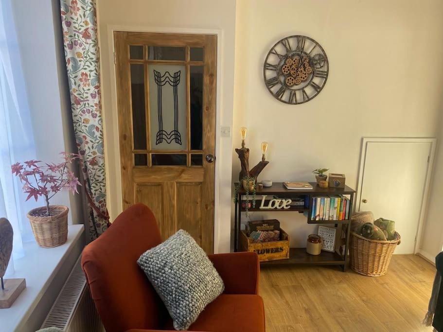 a living room with a chair and a door at Cosy cottage in Chard