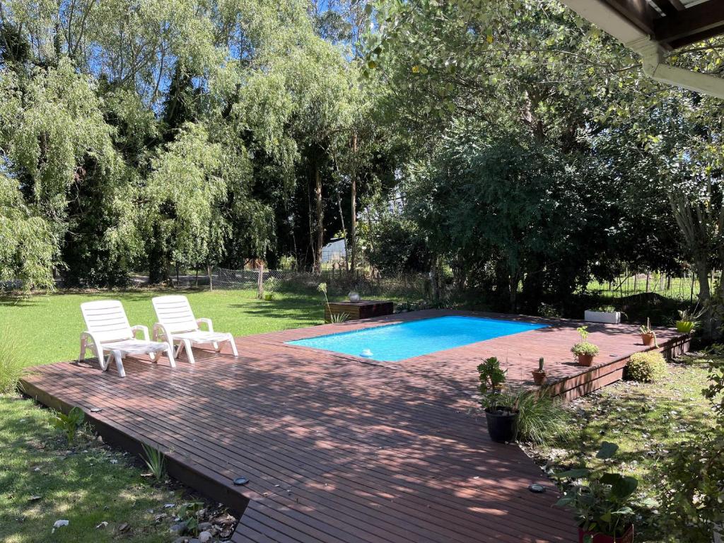 Dos sillas sentadas en una terraza junto a una piscina. en Casa Leo - Casa Con pileta en Zona Acantilados Para 4 PAX - Hola Sur, en Mar del Plata