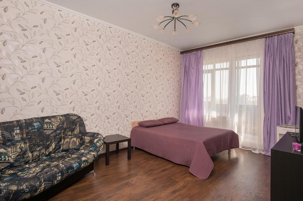 ノヴォシビルスクにあるApartments Freedom on Kirovaのリビングルーム(ベッド1台、ソファ付)