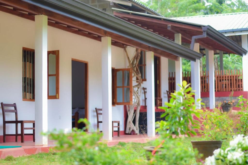 una casa con sedie e tavoli in un cortile di Sinharaja Forest Lodge a Deniyaya