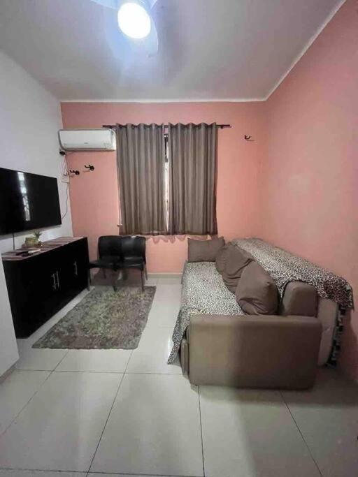 Il comprend un salon doté d'un canapé et d'une télévision à écran plat. dans l'établissement Apto conjugado 1 quadra praia, à Rio de Janeiro