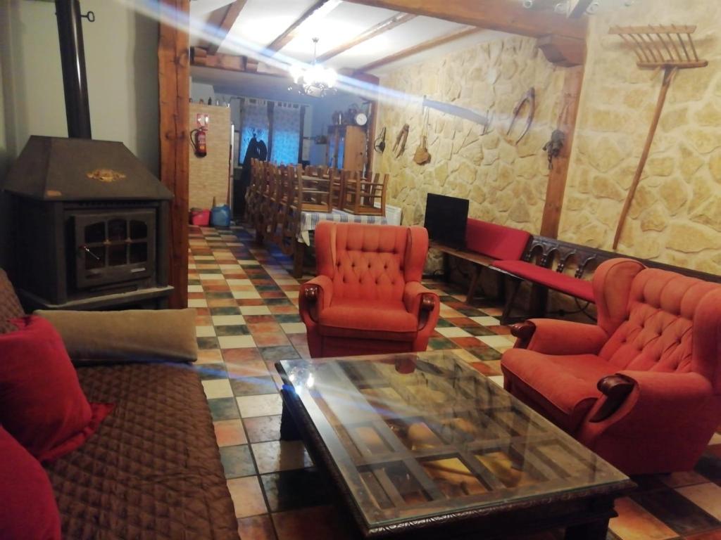uma sala de estar com cadeiras vermelhas e uma lareira em Casa rural El Balcón del Tajuña em Valfermoso de Tajuña