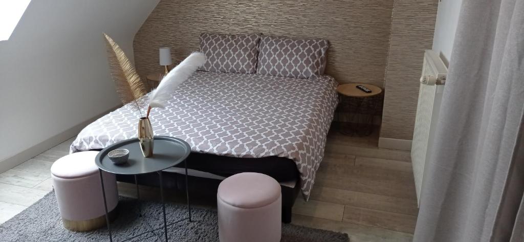 Dormitorio pequeño con cama y mesa en Au bonheur du logis, en Fougères
