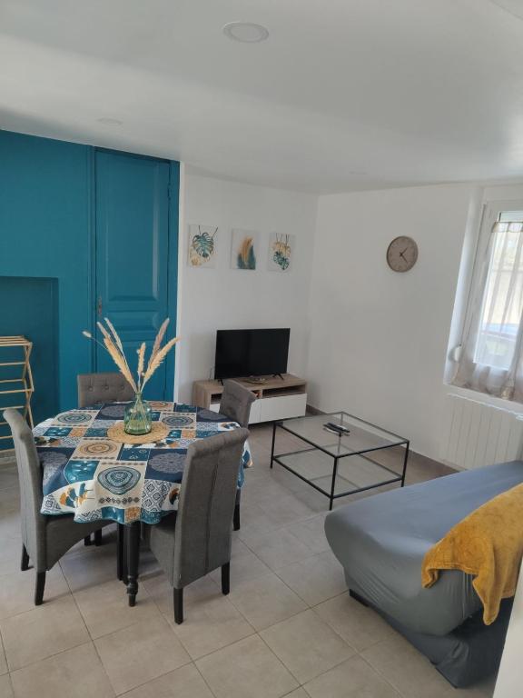 un salon avec une table avec des chaises et un canapé dans l'établissement Les hirondelles, à Arrest