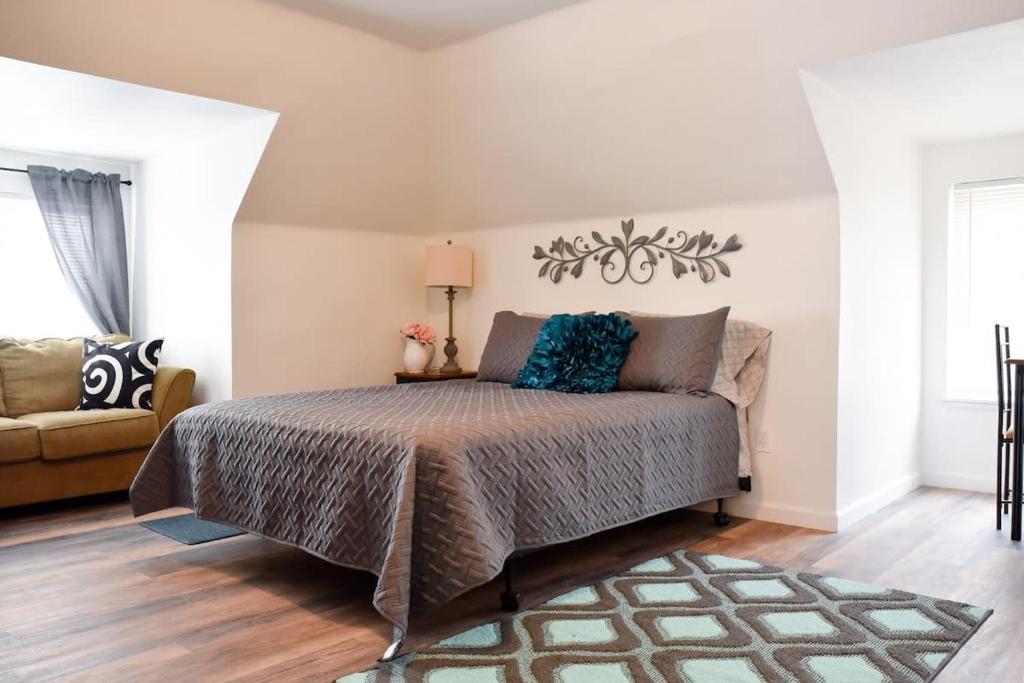 Unwind in a Bright Comfortable Apartment for 3 في بيتسبرغ: غرفة نوم بسرير واريكة