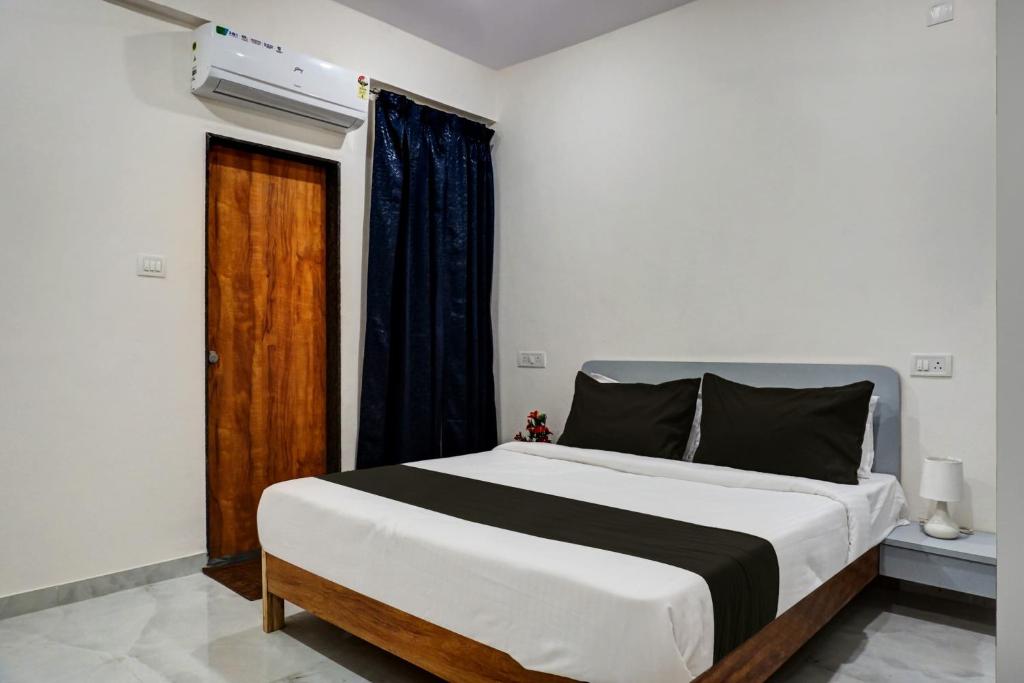 a bedroom with a large bed and a window at Super OYO Esta Inn in Pune
