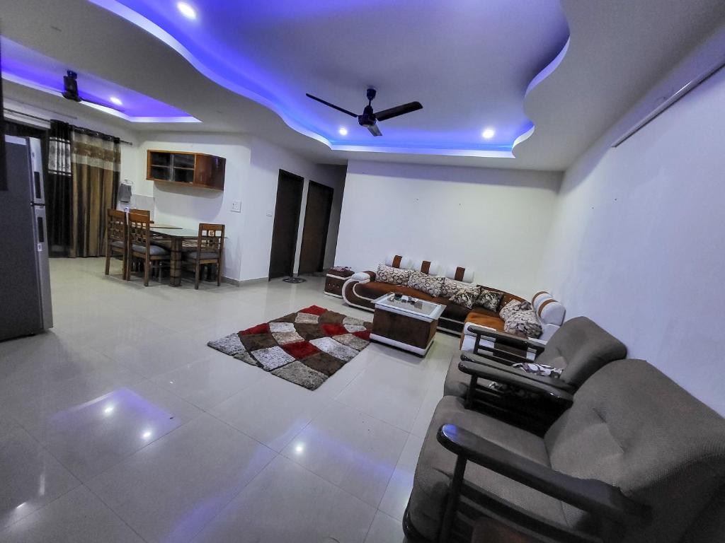 d'un salon avec des canapés et un plafond avec des lumières bleues. dans l'établissement Cozy Heaven, à Guwahati