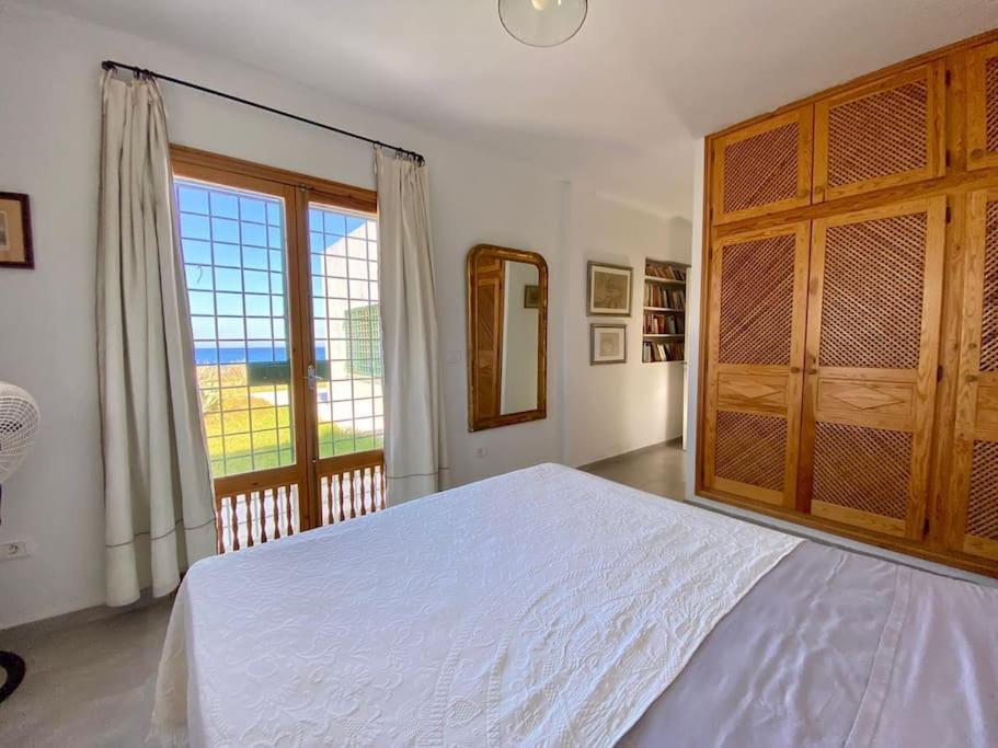 a bedroom with a large bed and a large window at Dar Brahim, Cap Zbib , Vue sur mer in Al Matlīn