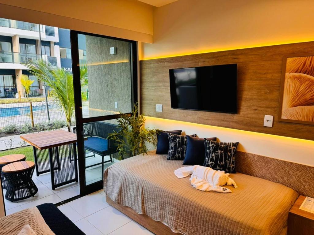 ein Schlafzimmer mit einem Bett und einem Flachbildfernseher in der Unterkunft Mana & Makia Slin Muro Alto in Porto De Galinhas
