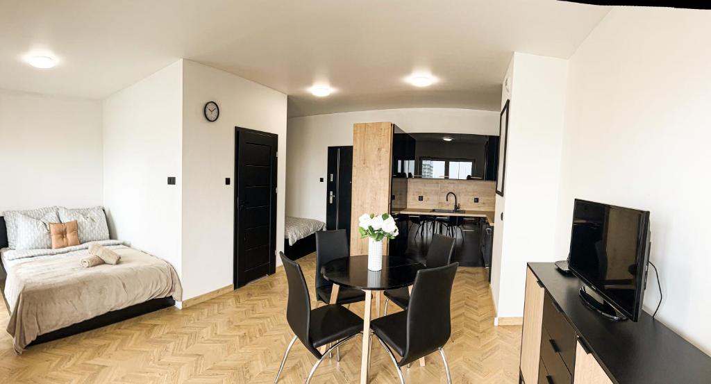 a living room with a bed a table and a television at Apartament Renard in Rzeszów