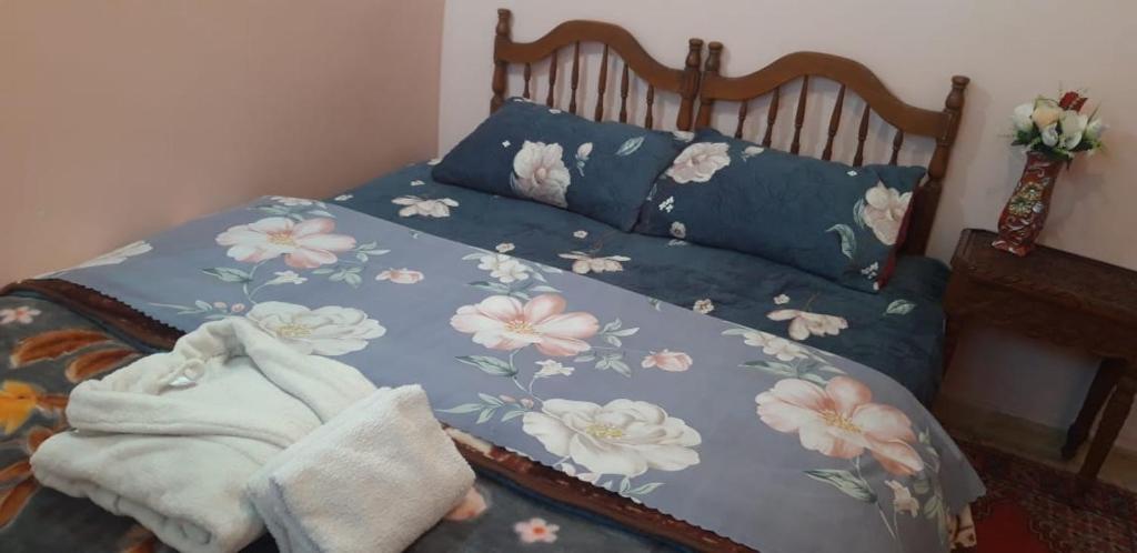 un letto con un piumone blu e fiori sopra di A 5 minutos del aeropuerto de fes a Oulad Tayeb
