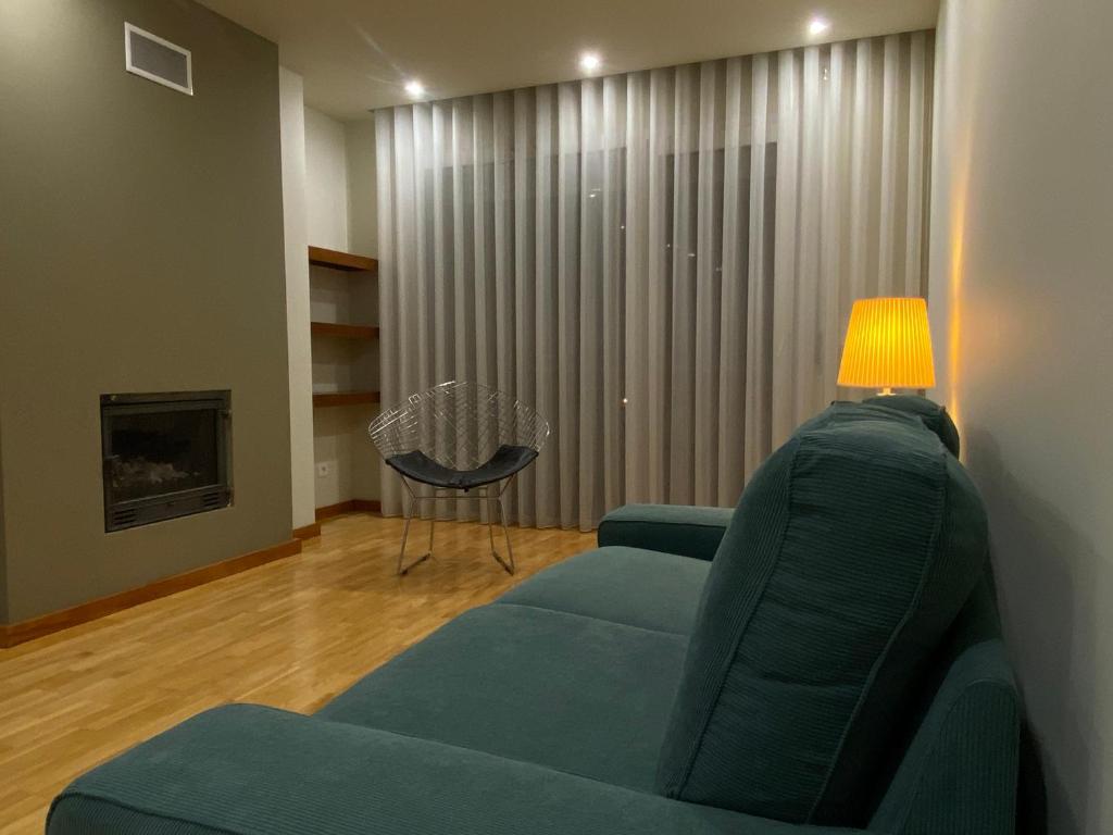 a living room with a blue couch and a lamp at Apartments Atlantis by UR in Vila Nova de Gaia