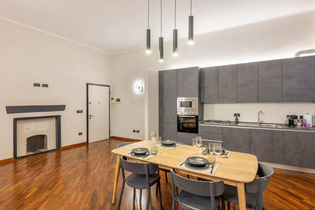 a dining room with a table and chairs and a kitchen at Palazzo dei Rolli Charm [Centro Storico di Genova] in Genova