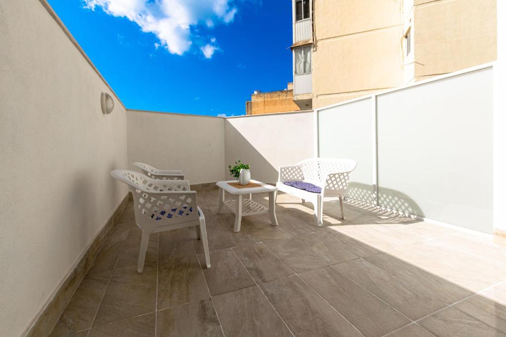 d'un balcon avec deux chaises et une table. dans l'établissement Spacious Brand New Apartment 3 Bdr 2 Bth Large Terrace, à San Pawl il-Baħar