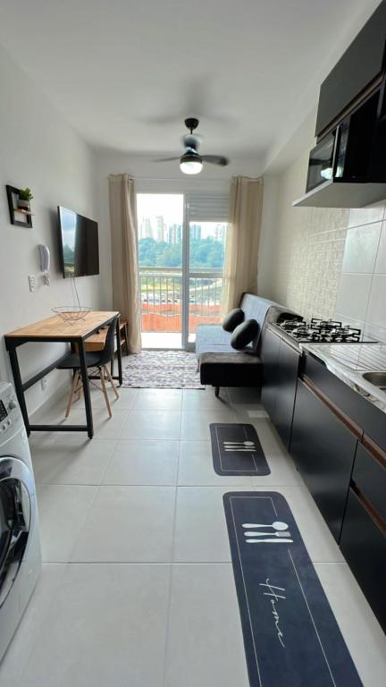 a kitchen and living room with a couch and a table at Ponte Laguna, Parque Burle Max in Sao Paulo