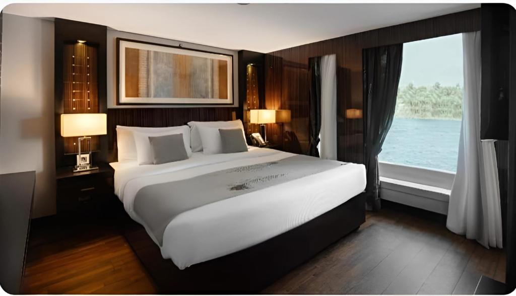 a bedroom with a large white bed and a window at NILE CRUISE LUXOR & ASWAN L in Aswan