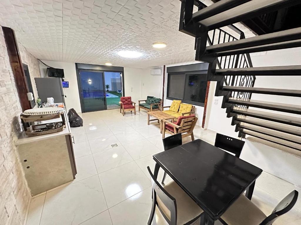 a living room with a table and chairs and a staircase at Jericho Palestine, Panorama Villa- View, Full Privacy & Pool in Jericho