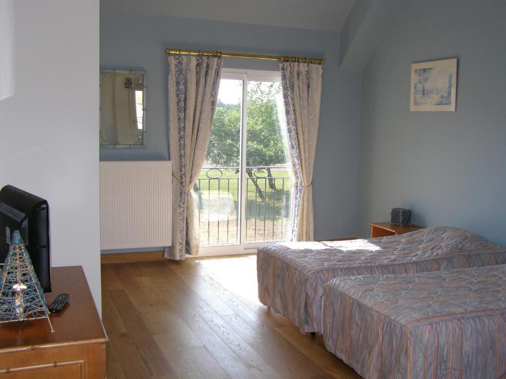 a bedroom with a bed and a large window at La Motte Melleraye in Donnery